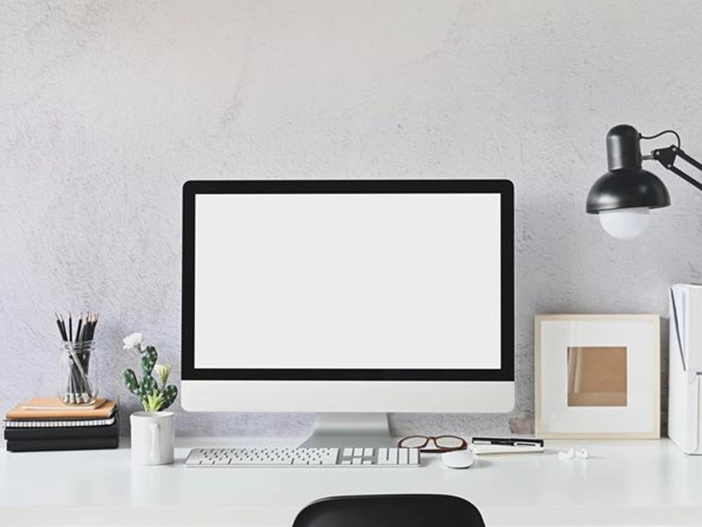 Escritório organizado em casa com mesa de trabalho, plantas e decoração aconchegante.